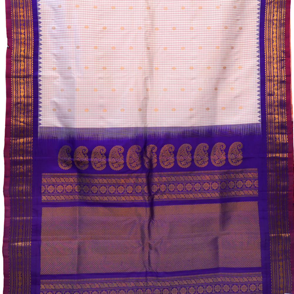Traditional Gadwal silk saree featuring zari-woven borders and contrast blouse piece.
