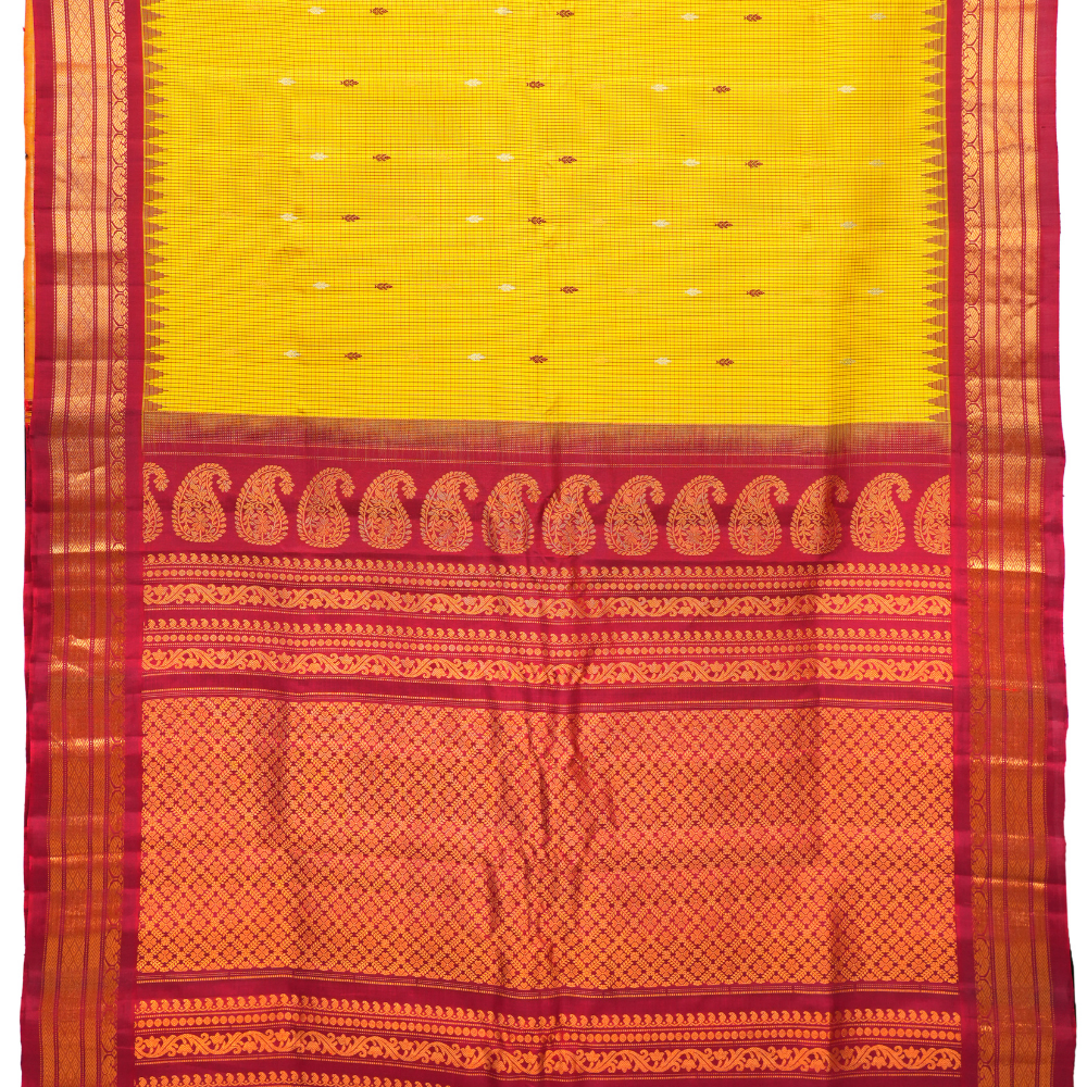 Traditional Gadwal silk saree featuring zari-woven borders and contrast blouse piece.
