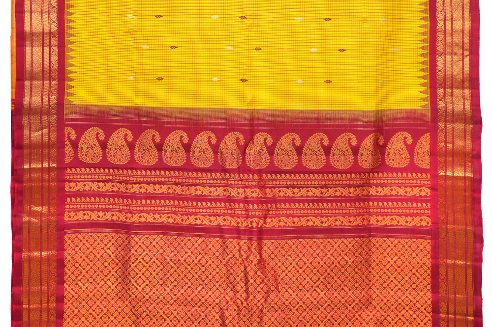 Traditional Gadwal silk saree featuring zari-woven borders and contrast blouse piece.
