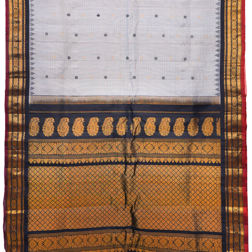 Traditional Gadwal silk saree featuring zari-woven borders and contrast blouse piece.
