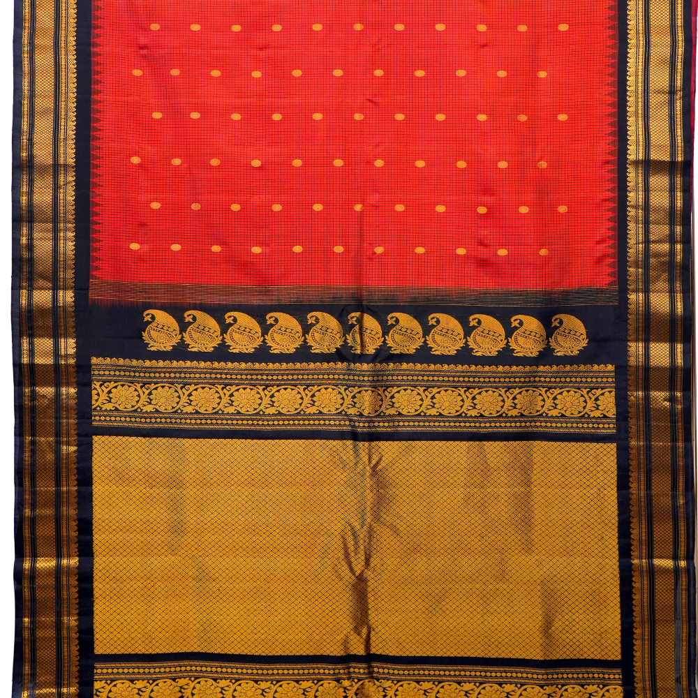 Traditional Gadwal silk saree featuring zari-woven borders and contrast blouse piece.
