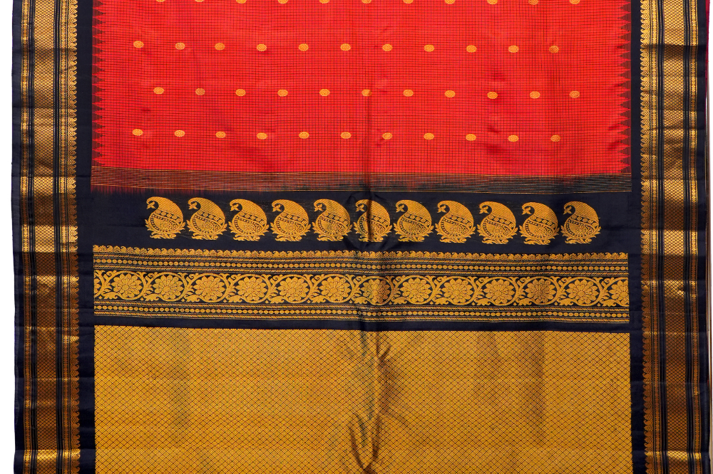 Traditional Gadwal silk saree featuring zari-woven borders and contrast blouse piece.
