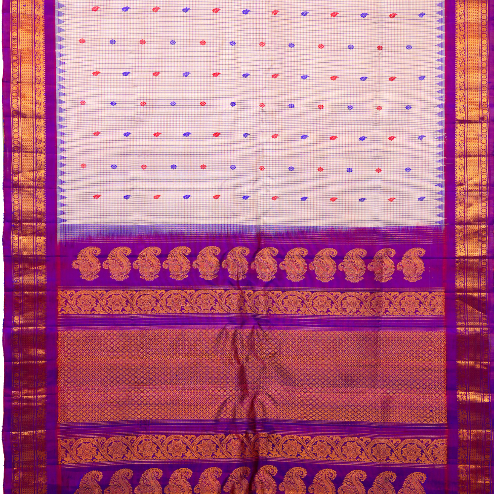 Traditional Gadwal silk saree featuring zari-woven borders and contrast blouse piece.
