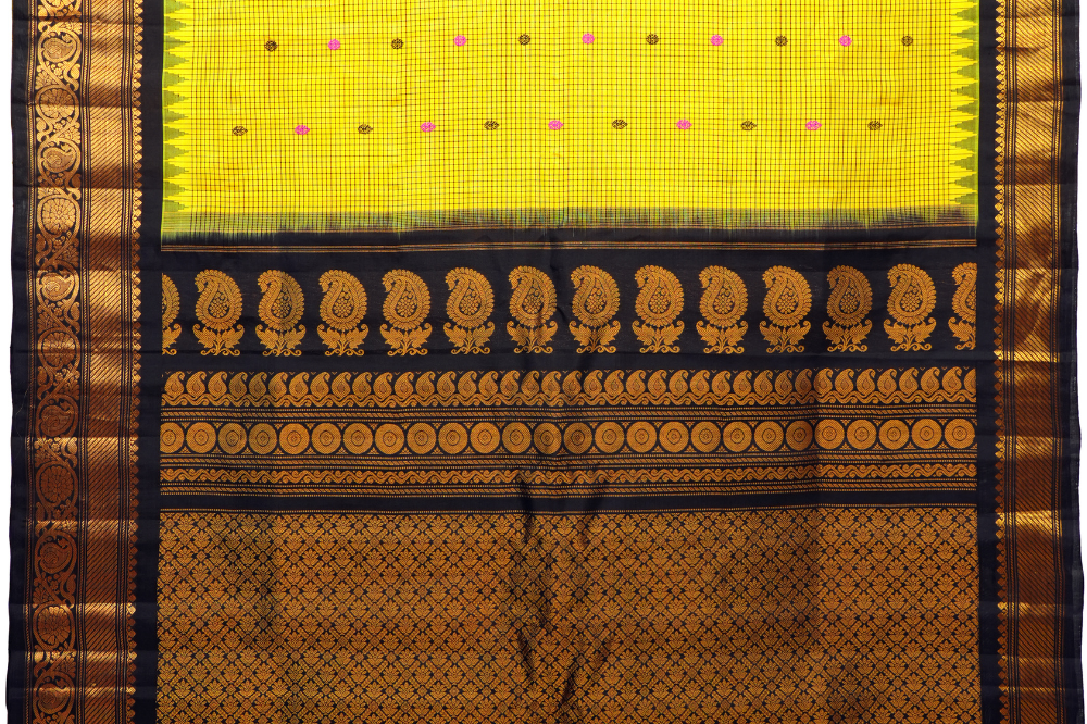 Traditional Gadwal silk saree featuring zari-woven borders and contrast blouse piece.
