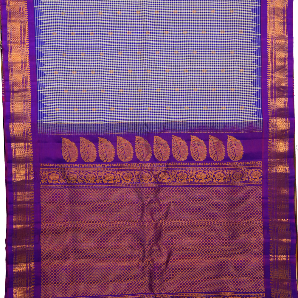 Traditional Gadwal silk saree featuring zari-woven borders and contrast blouse piece.
