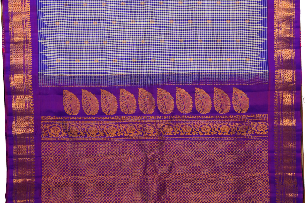 Traditional Gadwal silk saree featuring zari-woven borders and contrast blouse piece.
