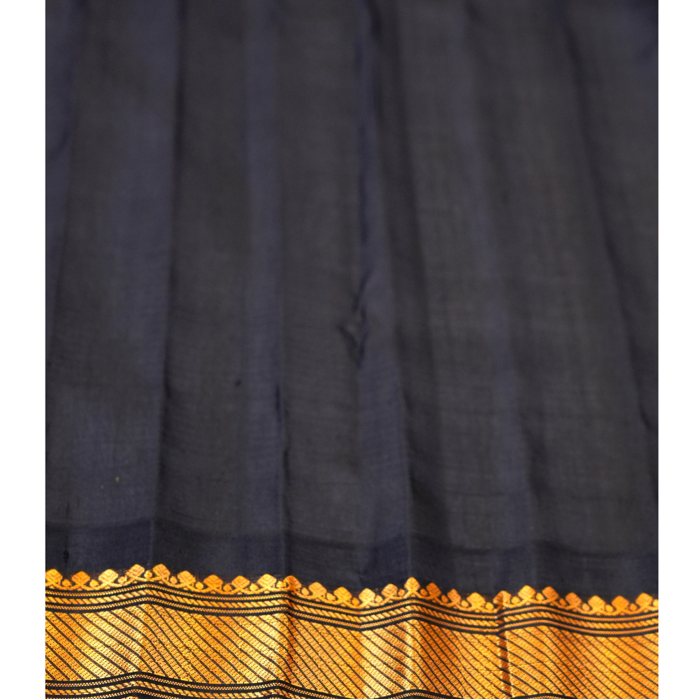 Handloom Gadwal silk cotton saree with all-over zari buttis and rich brocade pallu.
