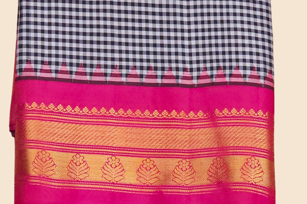 Traditional Gadwal silk saree featuring zari-woven borders and contrast blouse piece.
