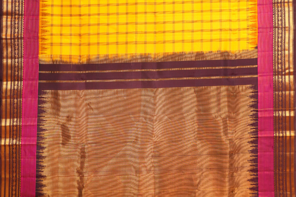 Traditional Gadwal silk saree featuring zari woven temple borders and contrast blouse.
