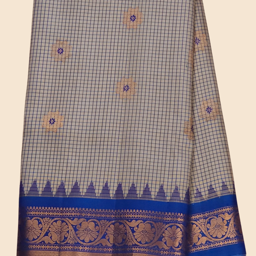 Traditional Gadwal silk saree featuring zari-woven borders and contrast blouse piece.
