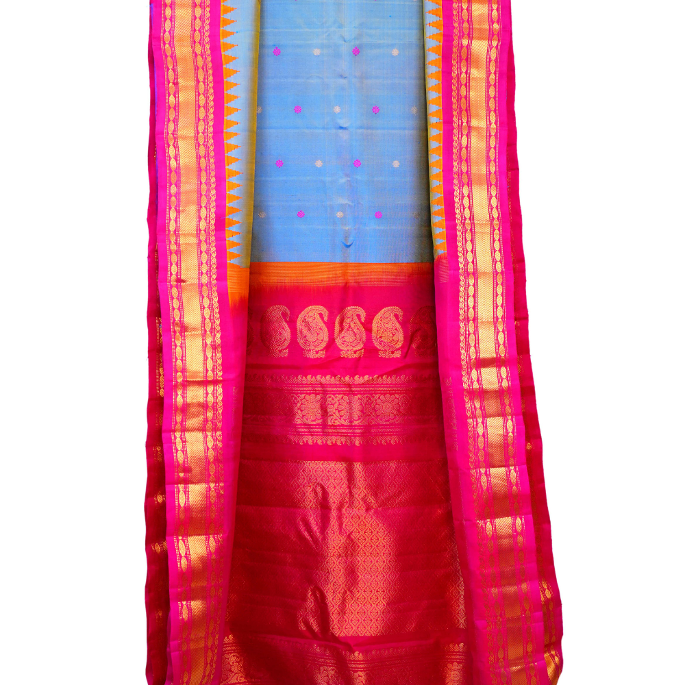 Traditional Gadwal silk saree featuring zari-woven borders and contrast blouse.
