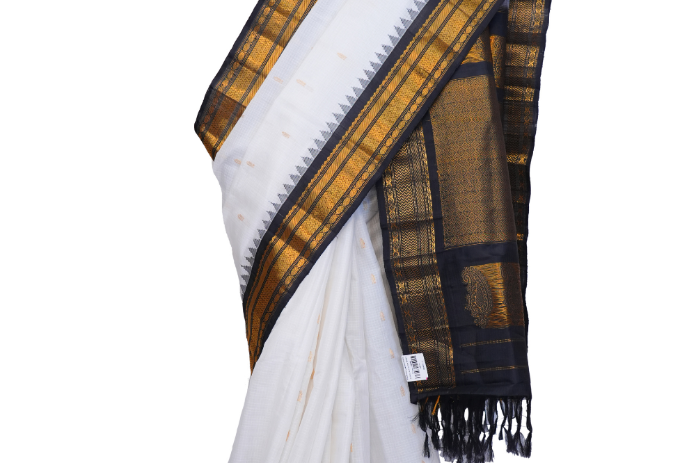 Handloom Gadwal silk cotton saree with all-over zari buttis and rich brocade pallu.
