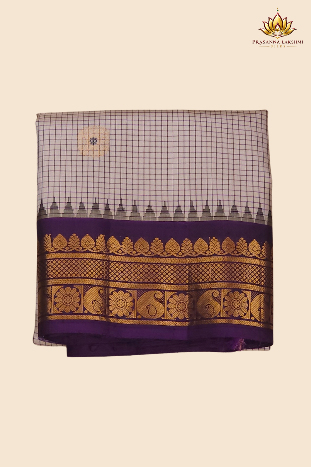 Traditional Gadwal silk saree featuring zari-woven borders and contrast blouse piece.
