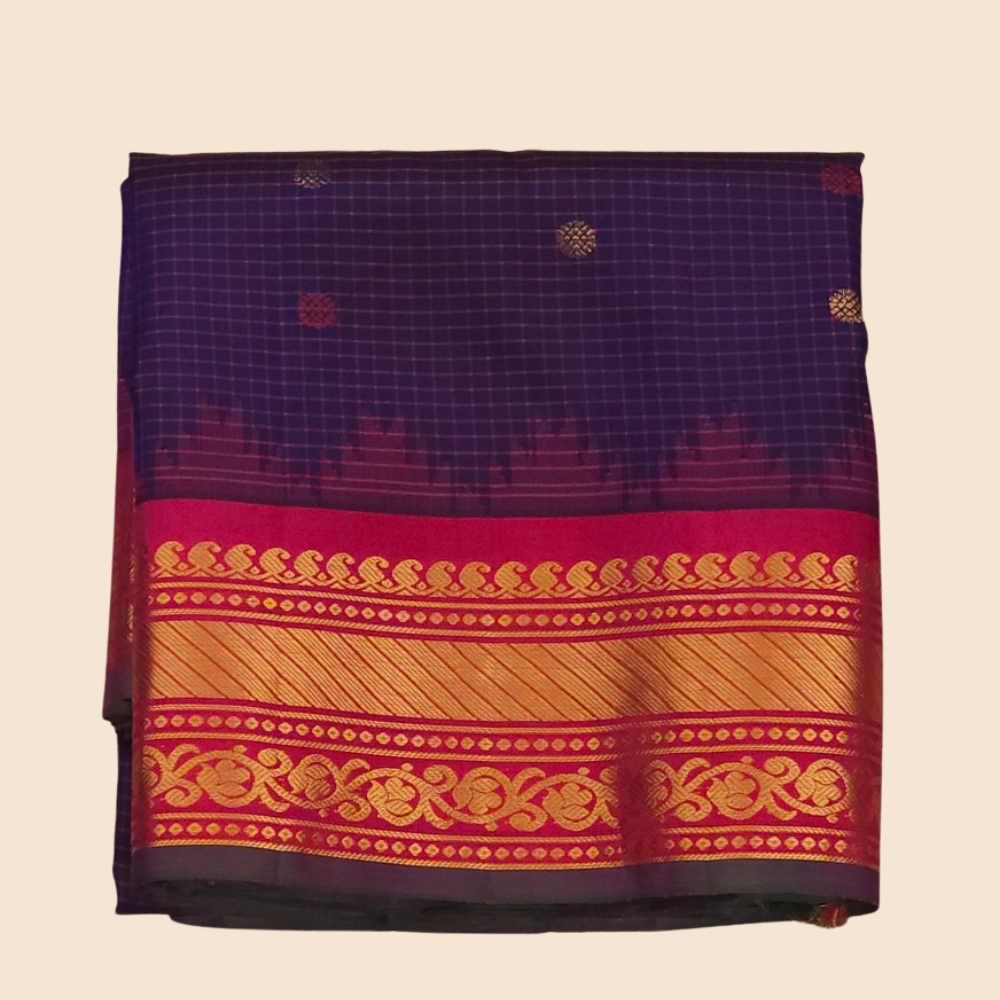 Traditional Gadwal silk saree featuring zari-woven borders and contrast blouse piece.
