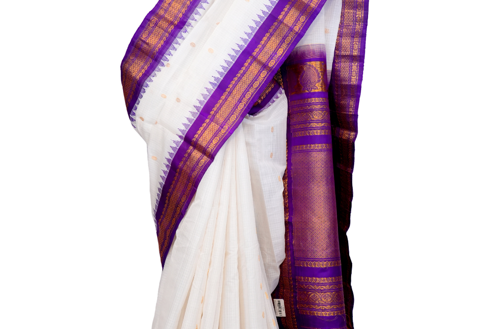 Handloom Gadwal silk cotton saree with all-over zari buttis and rich brocade pallu.

