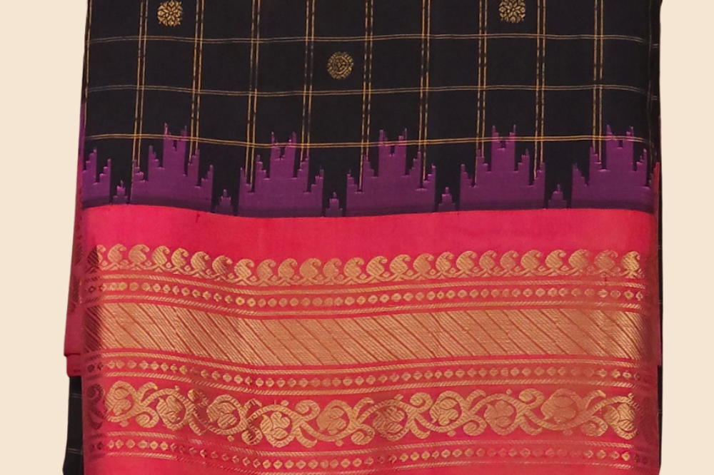 Traditional Gadwal silk saree featuring zari-woven borders and contrast blouse piece.
