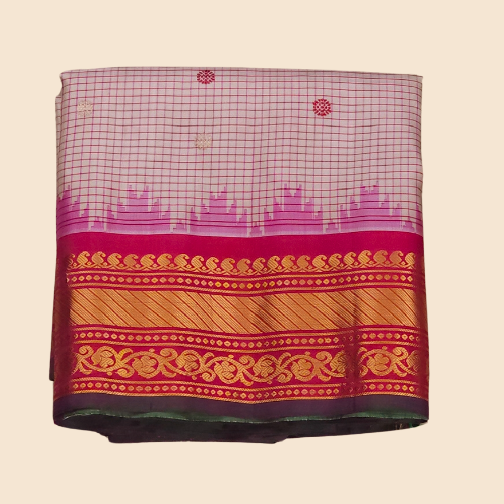 Traditional Gadwal silk saree featuring zari-woven borders and contrast blouse piece.
