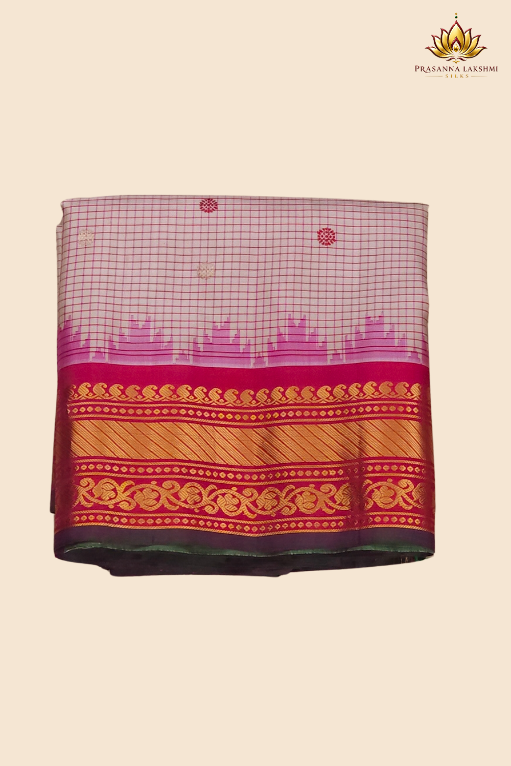 Traditional Gadwal silk saree featuring zari-woven borders and contrast blouse piece.
