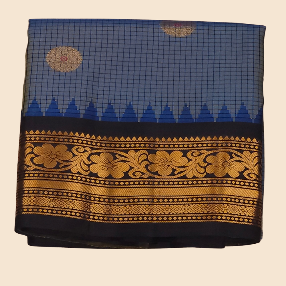 Traditional Gadwal silk saree featuring zari-woven borders and contrast blouse piece.

