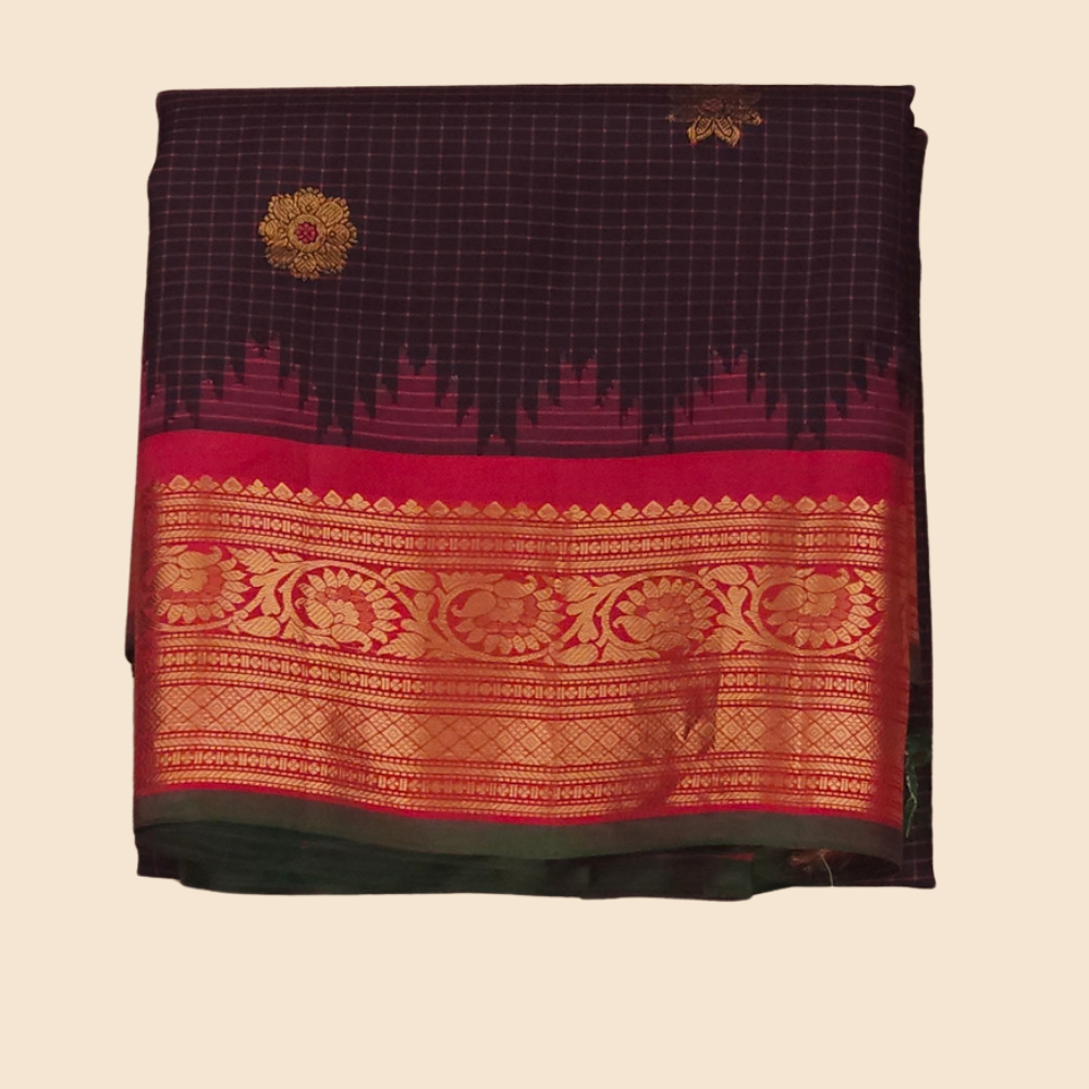 Traditional Gadwal silk saree featuring zari-woven borders and contrast blouse piece.
