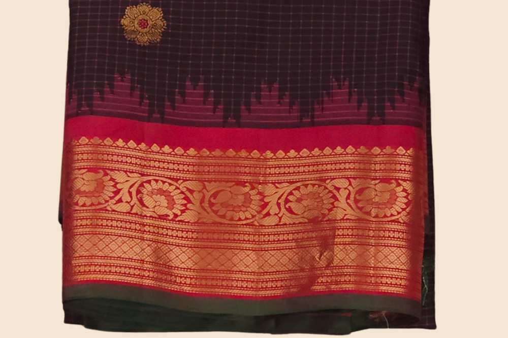 Traditional Gadwal silk saree featuring zari-woven borders and contrast blouse piece.

