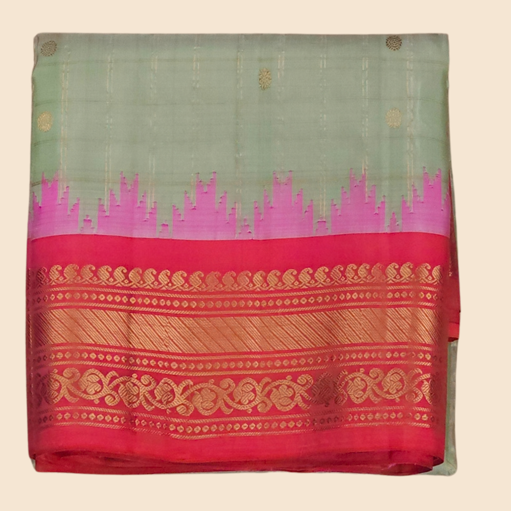 Traditional Gadwal silk saree featuring zari-woven borders and contrast blouse piece.
