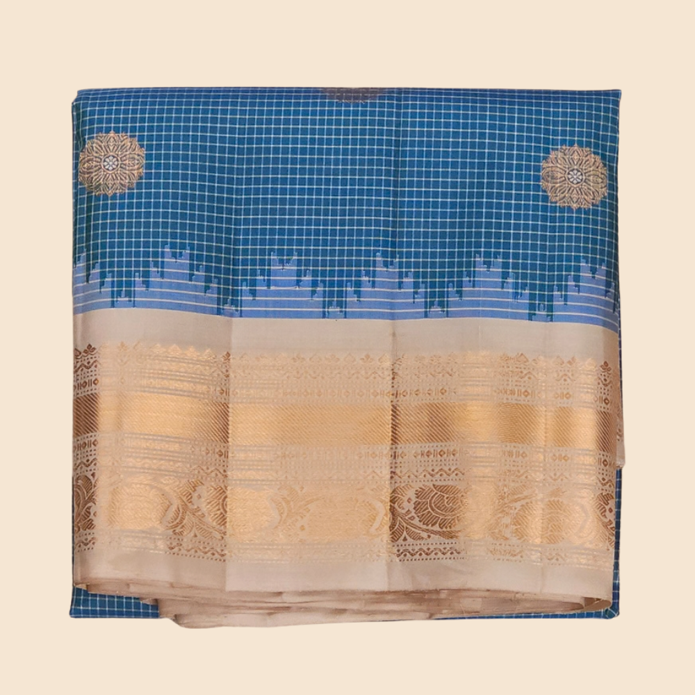 Traditional Gadwal silk saree featuring zari-woven borders and contrast blouse piece.
