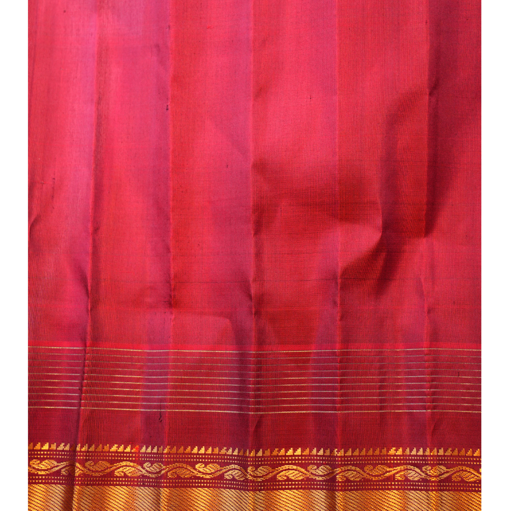 Traditional Gadwal silk saree featuring zari-woven borders and contrast blouse.
