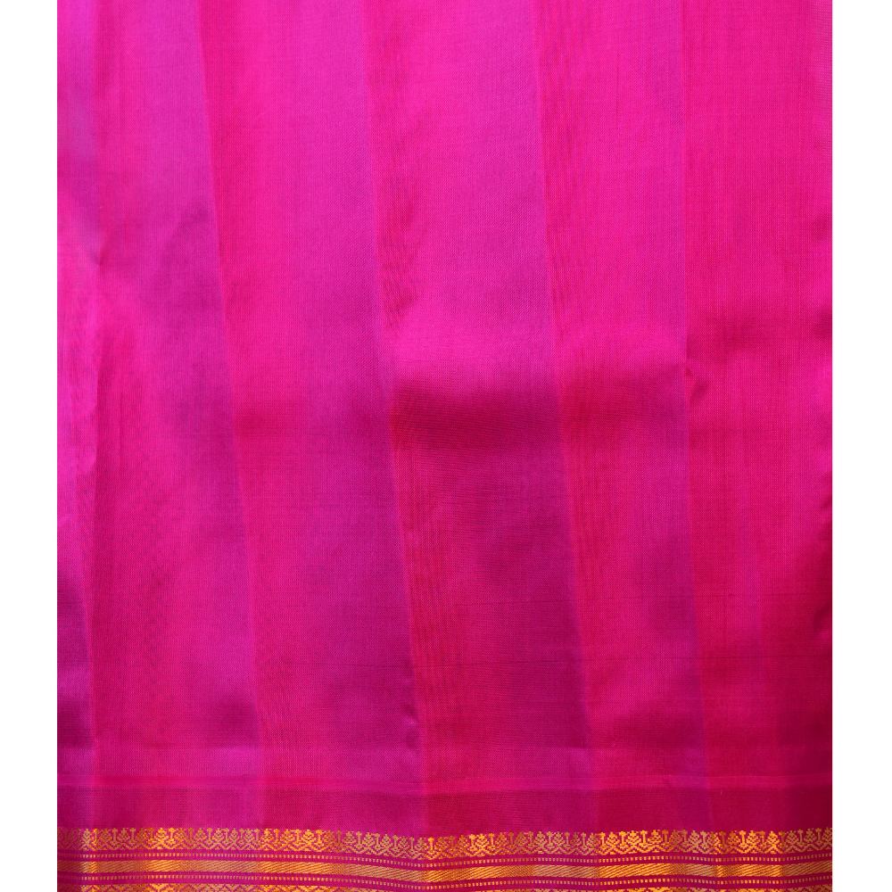 Traditional Gadwal silk saree featuring zari-woven borders and contrast blouse.
