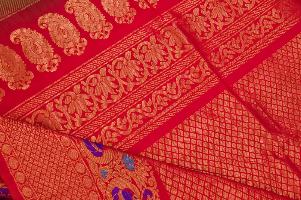 Premium Gadwal Silk Saree with woven zari motifs, luxurious brocade pallu, meenakari turning border, and matching contrast blouse.
