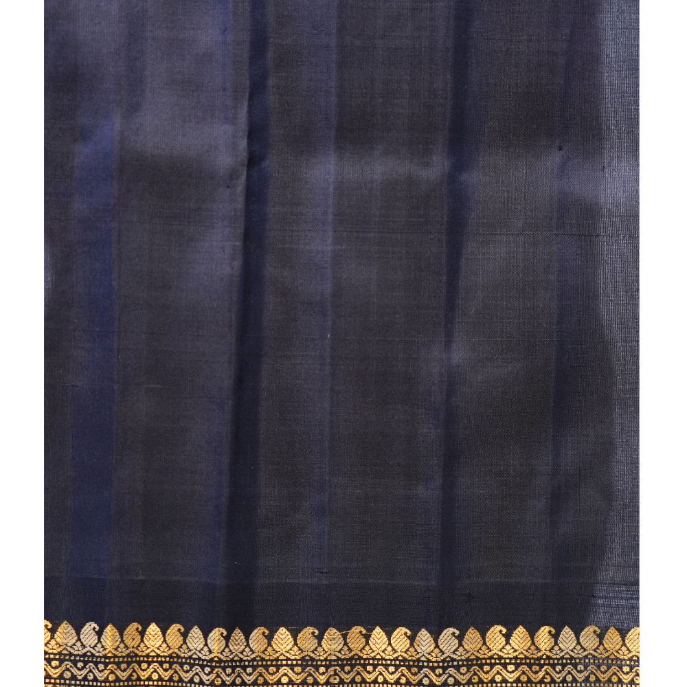 Traditional Gadwal silk saree featuring zari-woven borders and contrast blouse.
