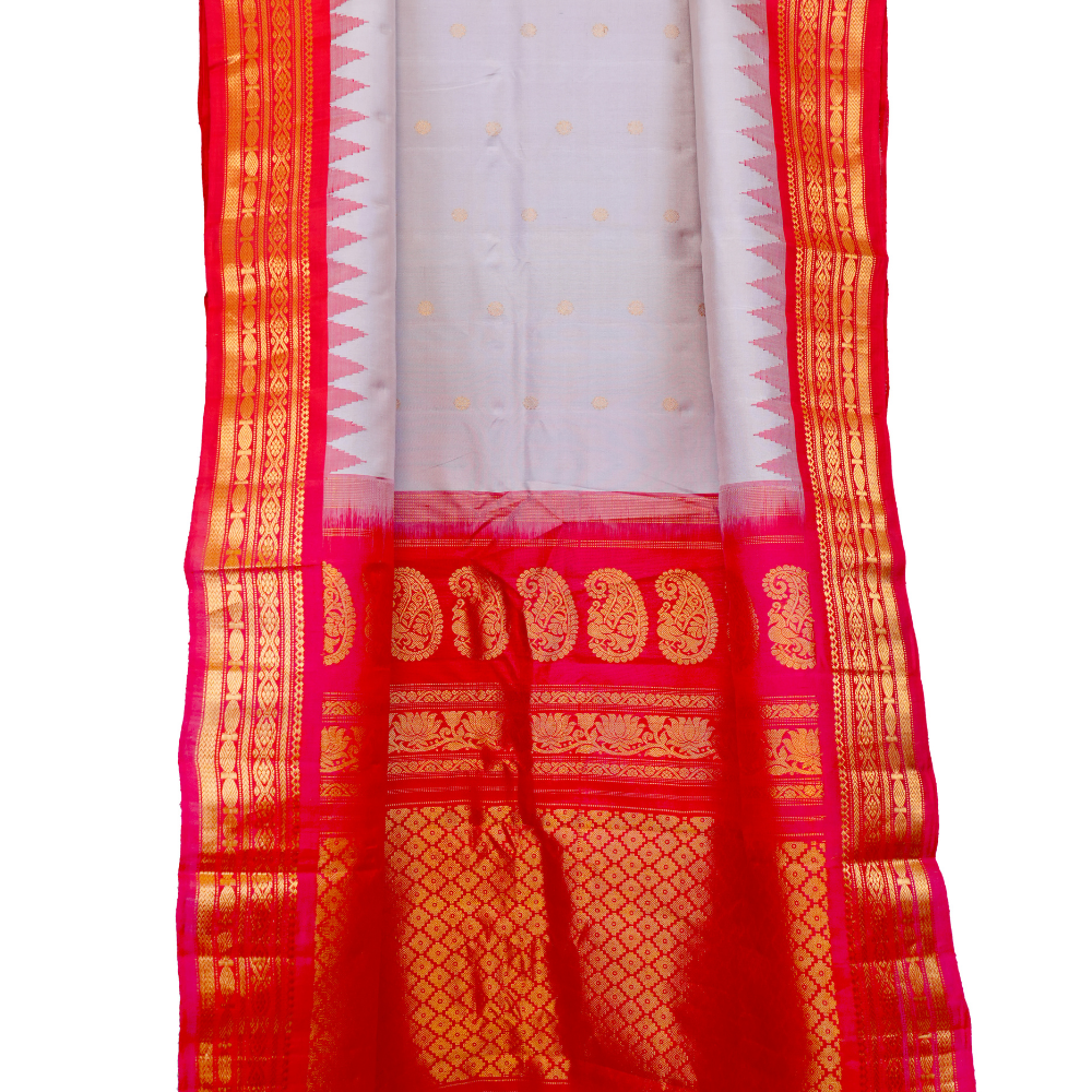Traditional Gadwal silk saree featuring zari-woven borders and contrast blouse.
