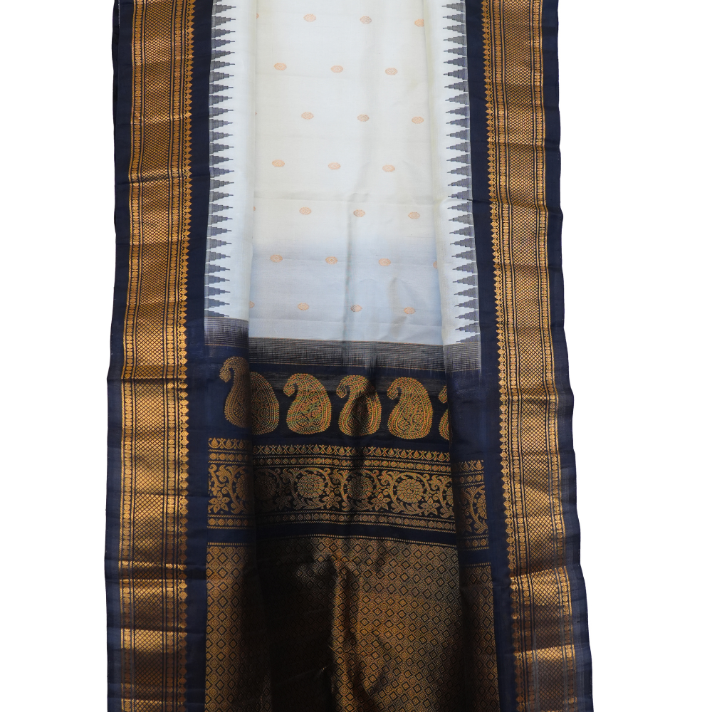 Traditional Gadwal silk saree featuring zari-woven borders and contrast blouse.
