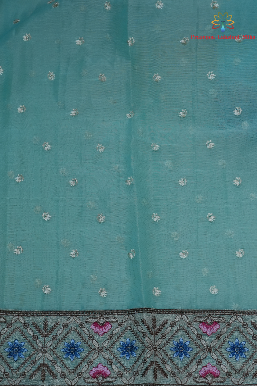 Elegant ethnic organza saree featuring floral pallu design and matching running blouse.
