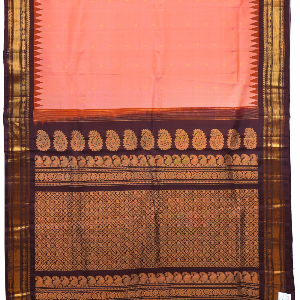 Traditional Gadwal silk saree featuring zari-woven borders and contrast blouse.
