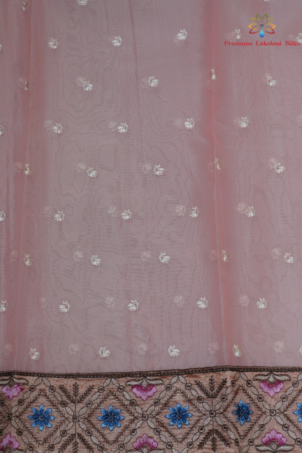 Elegant ethnic organza saree featuring floral pallu design and matching running blouse.
