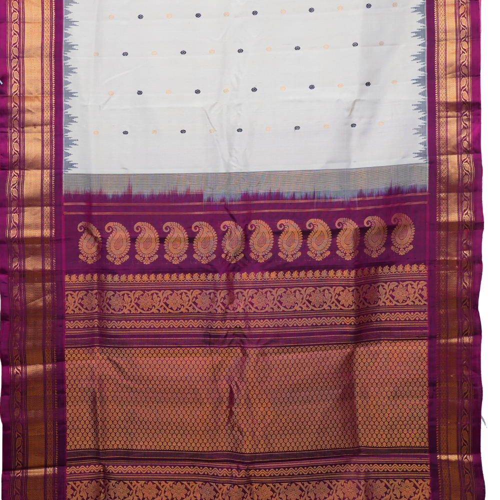 Traditional Gadwal silk saree featuring zari-woven borders and contrast blouse.