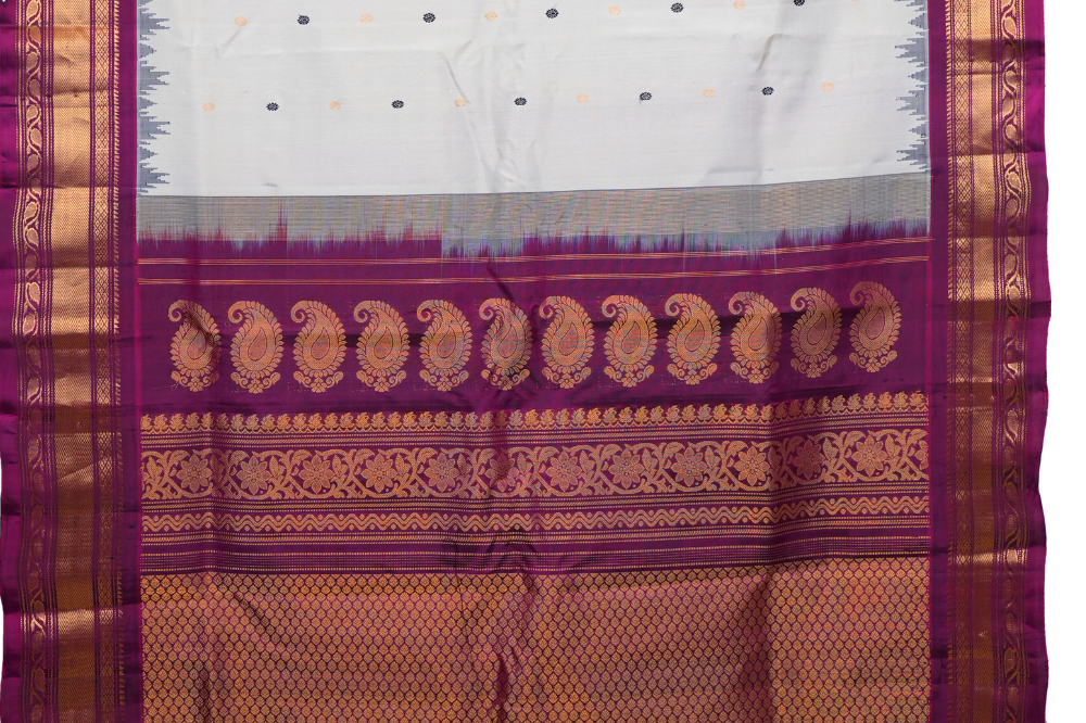 Traditional Gadwal silk saree featuring zari-woven borders and contrast blouse.