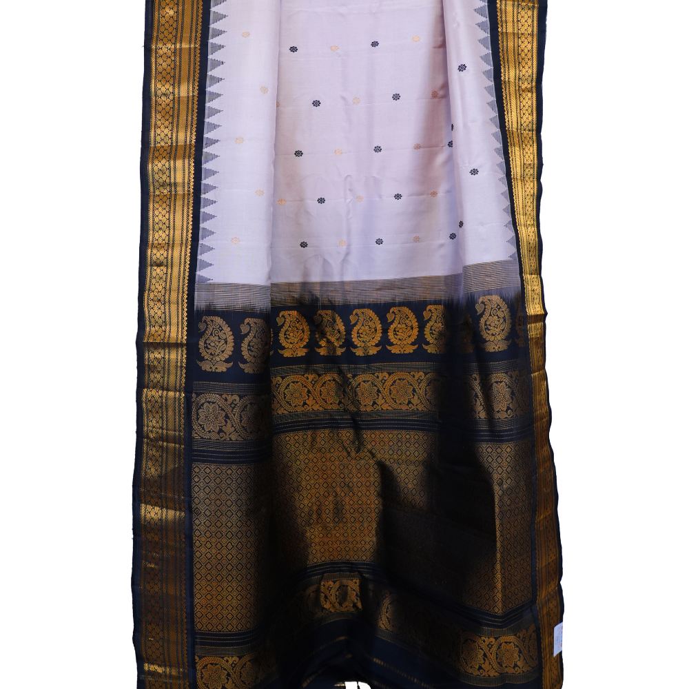 Traditional Gadwal silk saree featuring zari-woven borders and contrast blouse.
