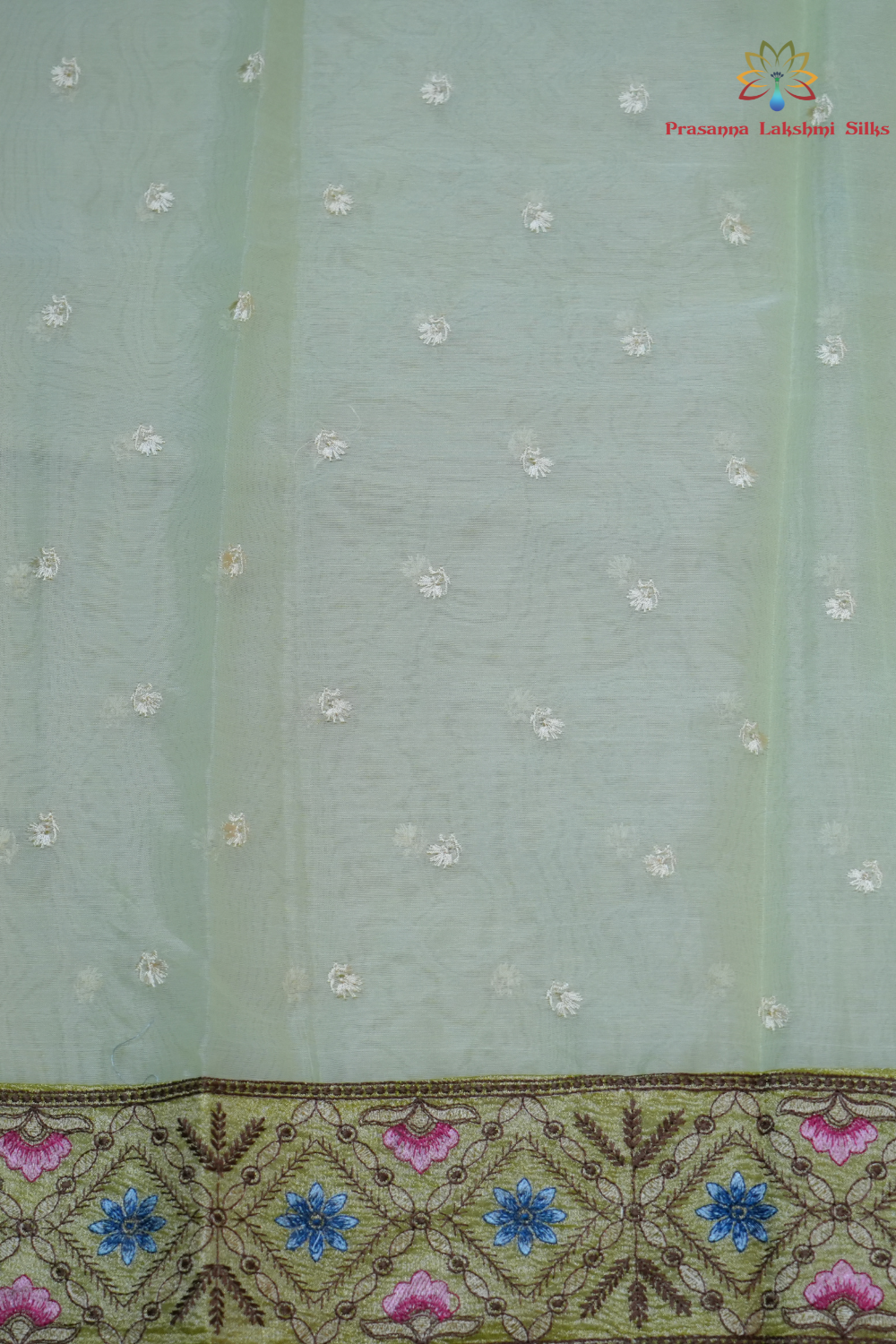 Elegant ethnic organza saree featuring floral pallu design and matching running blouse.
