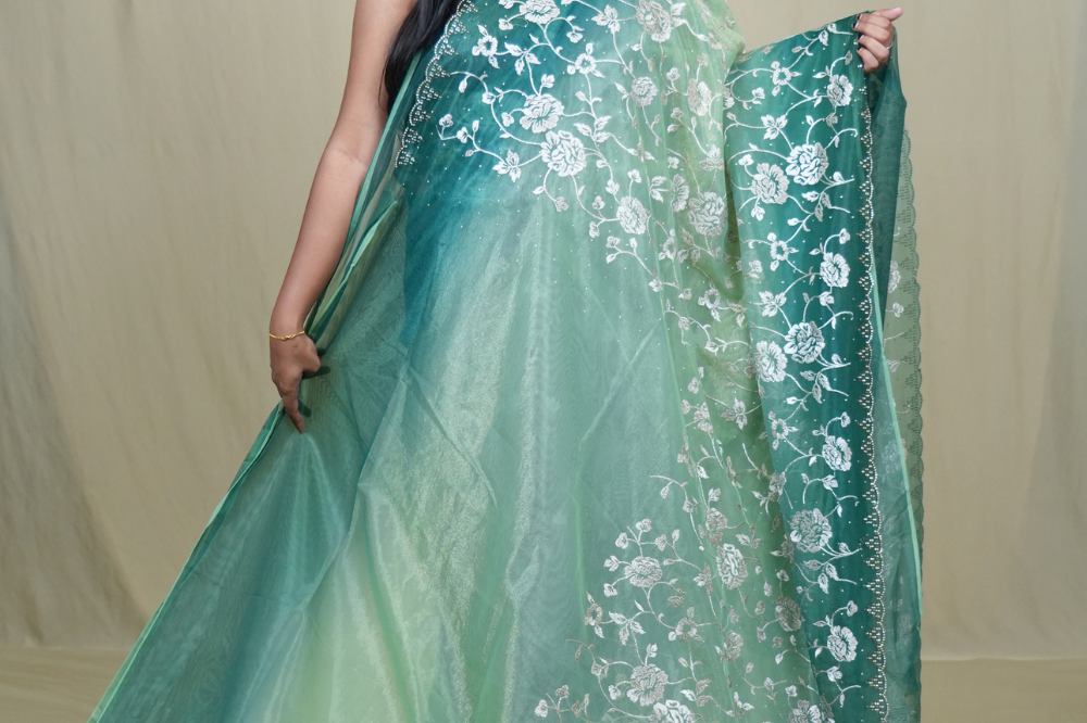 Elegant ethnic tissue saree featuring cutwork borders and graceful running pallu design.
