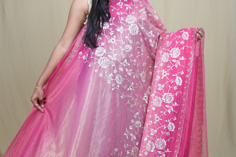 Elegant ethnic tissue saree featuring cutwork borders and graceful running pallu design.
