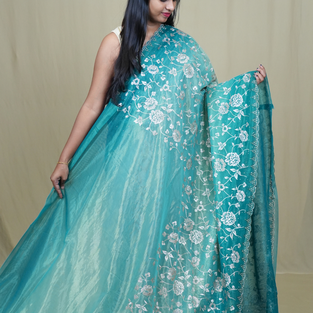 Elegant ethnic tissue saree featuring cutwork borders and graceful running pallu design.
