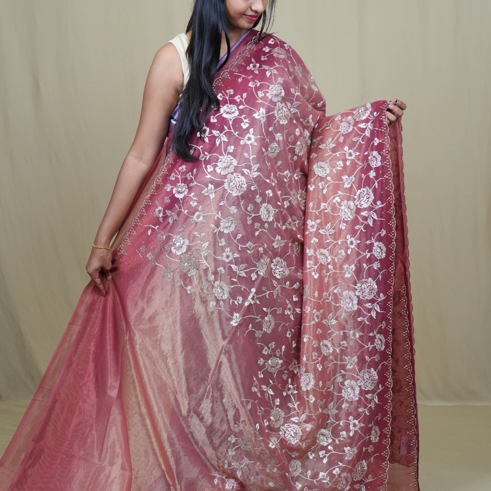 Elegant ethnic tissue saree featuring cutwork borders and graceful running pallu design.
