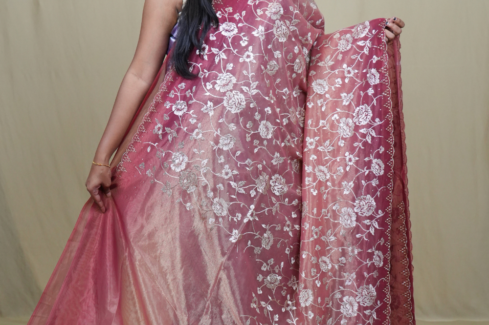 Elegant ethnic tissue saree featuring cutwork borders and graceful running pallu design.
