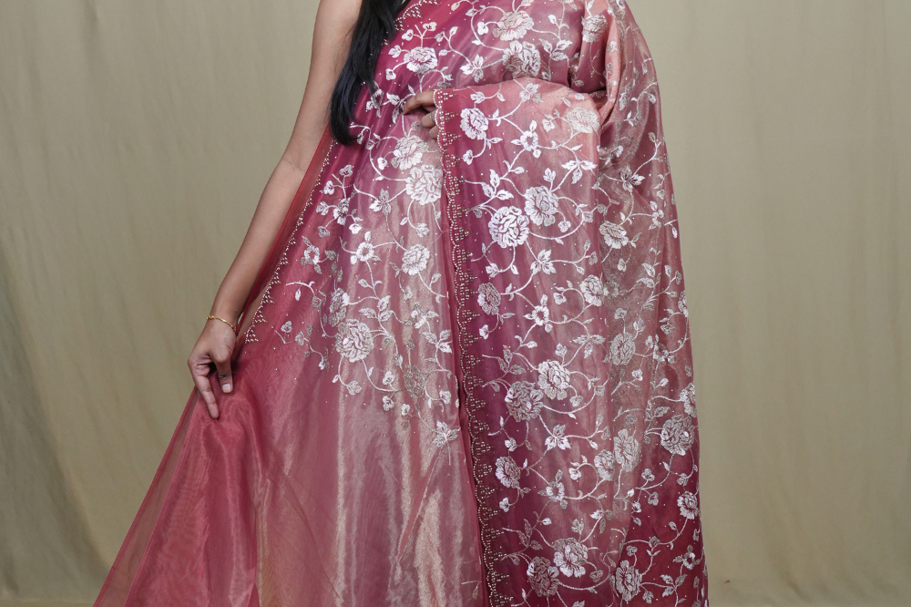 Exquisite Tissue Net Saree with all-over silver zari floral embroidery and bead detailing.
