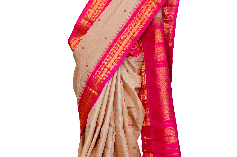 Handloom Gadwal silk cotton saree with all-over zari buttis and rich brocade pallu.
