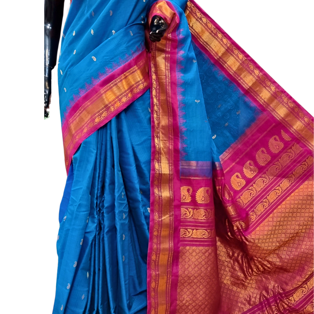 Handloom Gadwal silk cotton saree with all-over zari buttis and rich brocade pallu.

