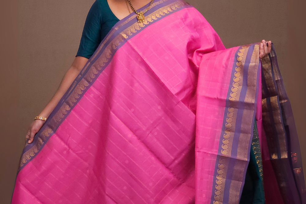 Woman wearing a pink saree with a brown background