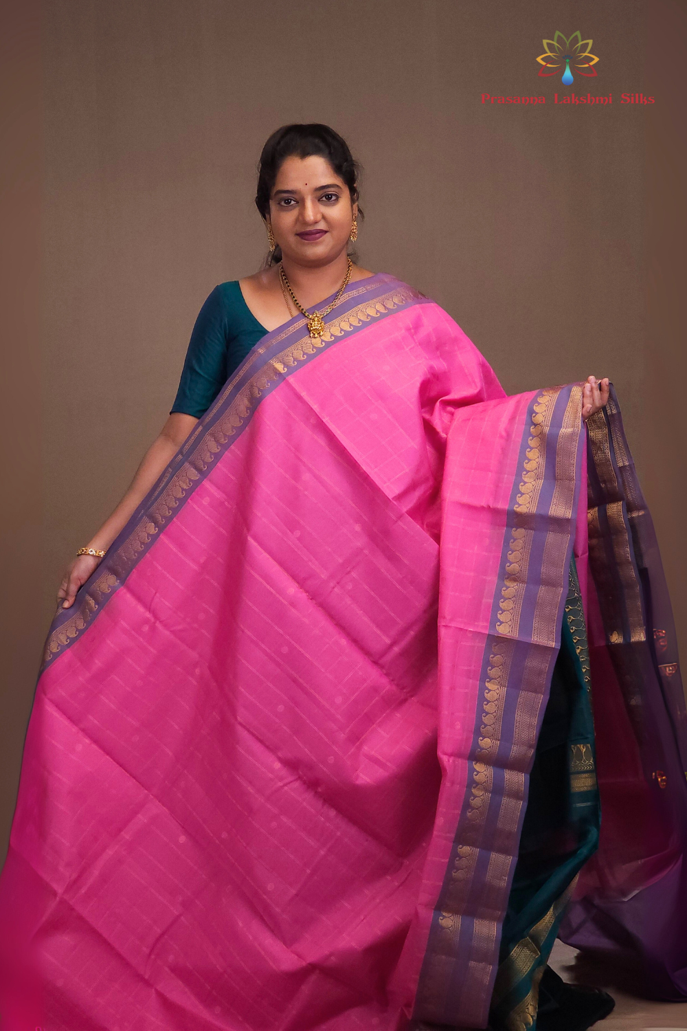 Woman wearing a pink saree with a brown background